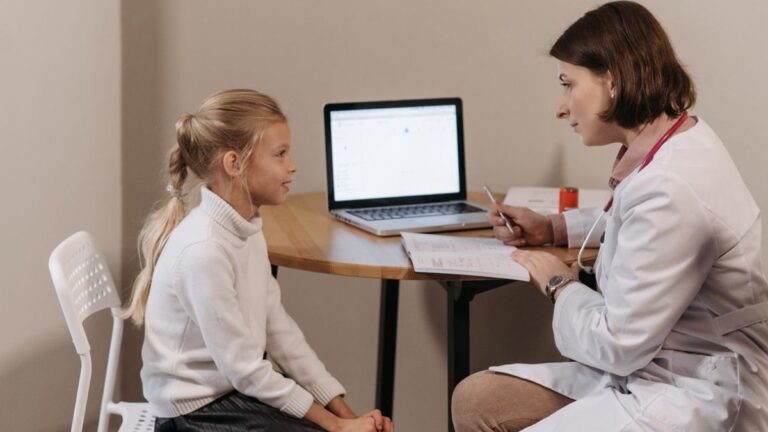 청원구 대상포진 예방접종 글 대표이미지 · 사진: Doctor in lab coat consulting a young girl in a clinic with a laptop on the table.