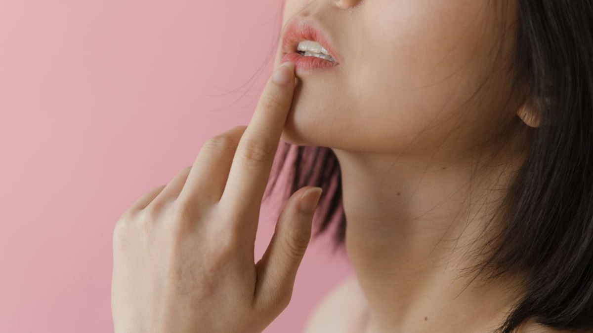 피부 증상(두드러기·혈관부종)은 언제 응급실로 가야 할까요? — 두드러기 자체는 대부분 급성이며 항히스타민제 복용 후 1 2시간 정도면 가라앉는 경우가 많아, 가려움과 발진만 있다면 응급실보다… · 사진: Close-up portrait of a woman gently touching her lip against a p…