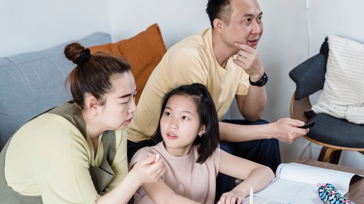 아이가 검사를 낯설어한다면 어떻게 준비하면 좋을까요? — 검사 과정을 미리 간단히 설명해주세요 따끔한 느낌이 잠깐 있을 수 있다는 정도로 미리 알려주시면, 아이가 예상하지 못한 자극에… · 사진: Parents helping daughter with homework in a cozy living room setting.